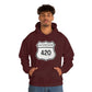 A young man wearing a maroon Interstate 420 marijuana hoodie with his hands in his hoodie pocket