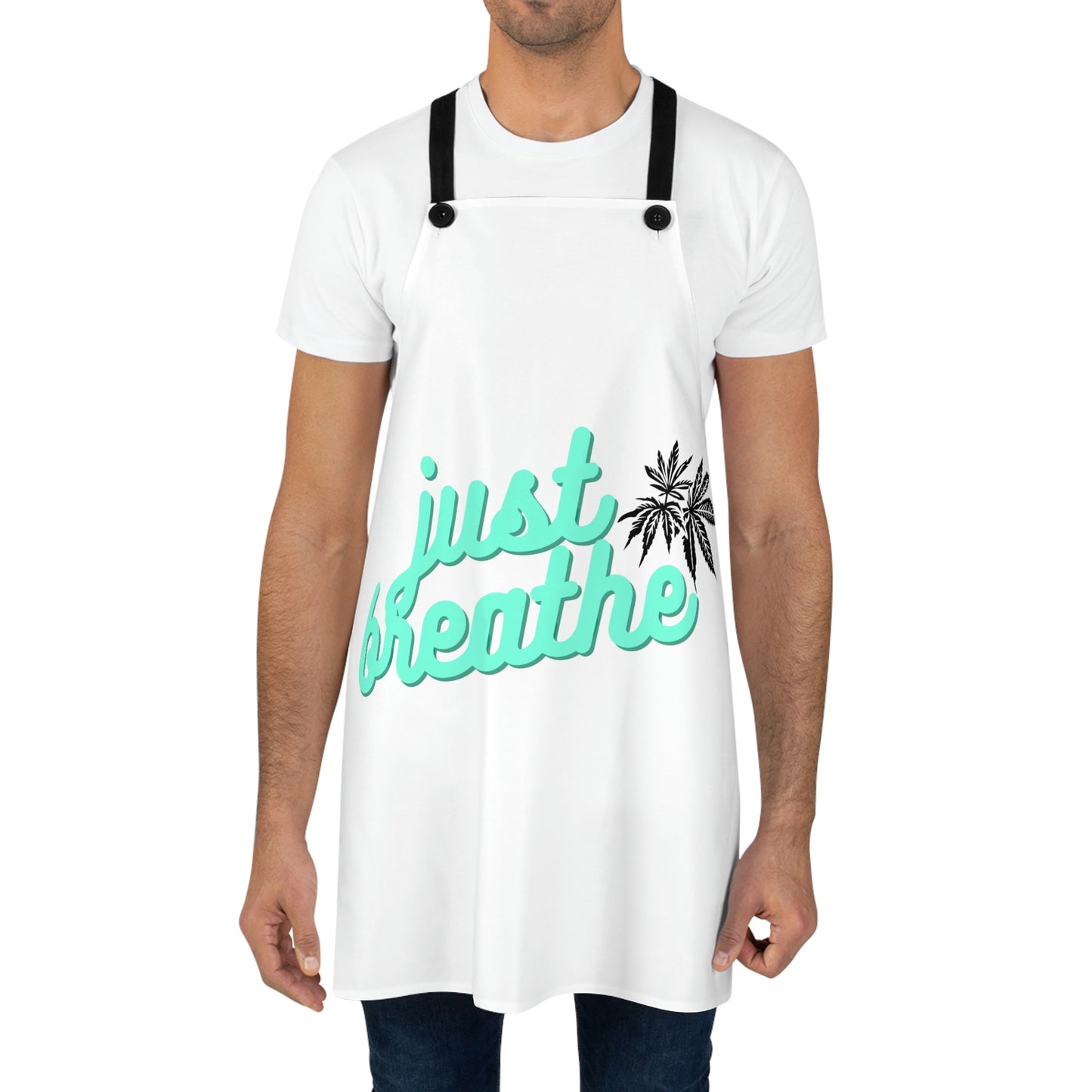 A man is wearing the Just Breathe Cannabis Chef's Apron with black marijuana leaves