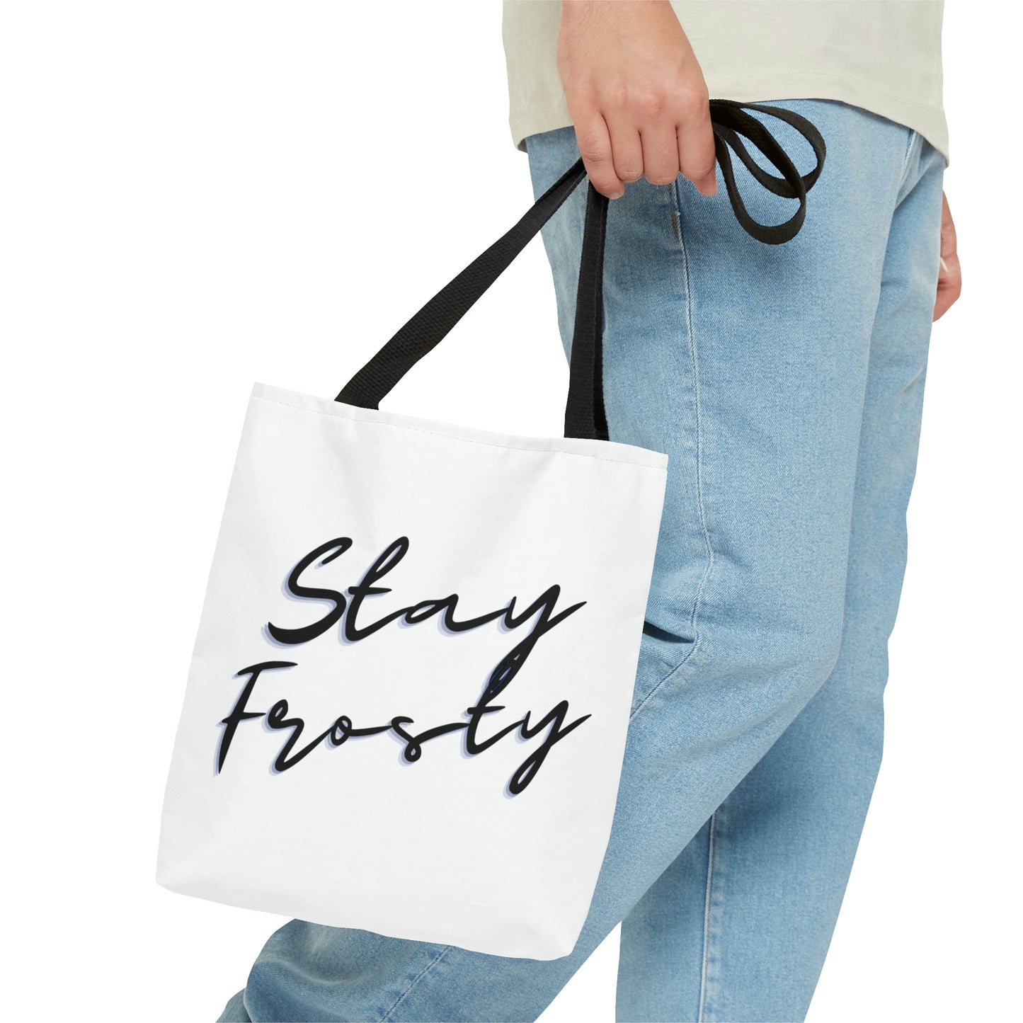 A man holds the Stay Frosty White Weed Tote Bag with cool black straps