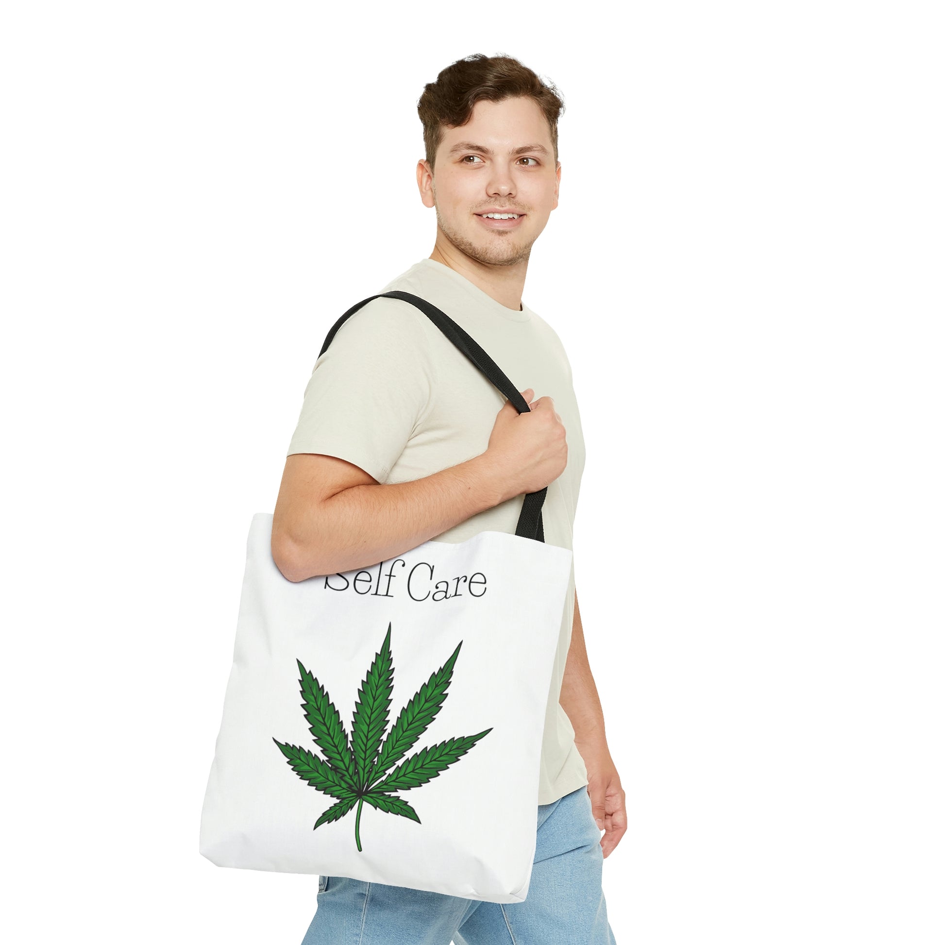 A man in a tan shirt is looking really happy as he wears the Self Care Cannabis Tote Bag with weed leaf