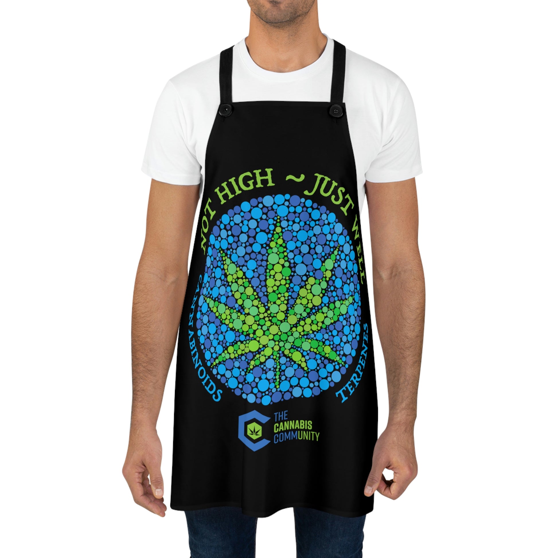 A man wearing the black blue and green Not High, Just Well Chef's Apron with cannabis leaf in the center