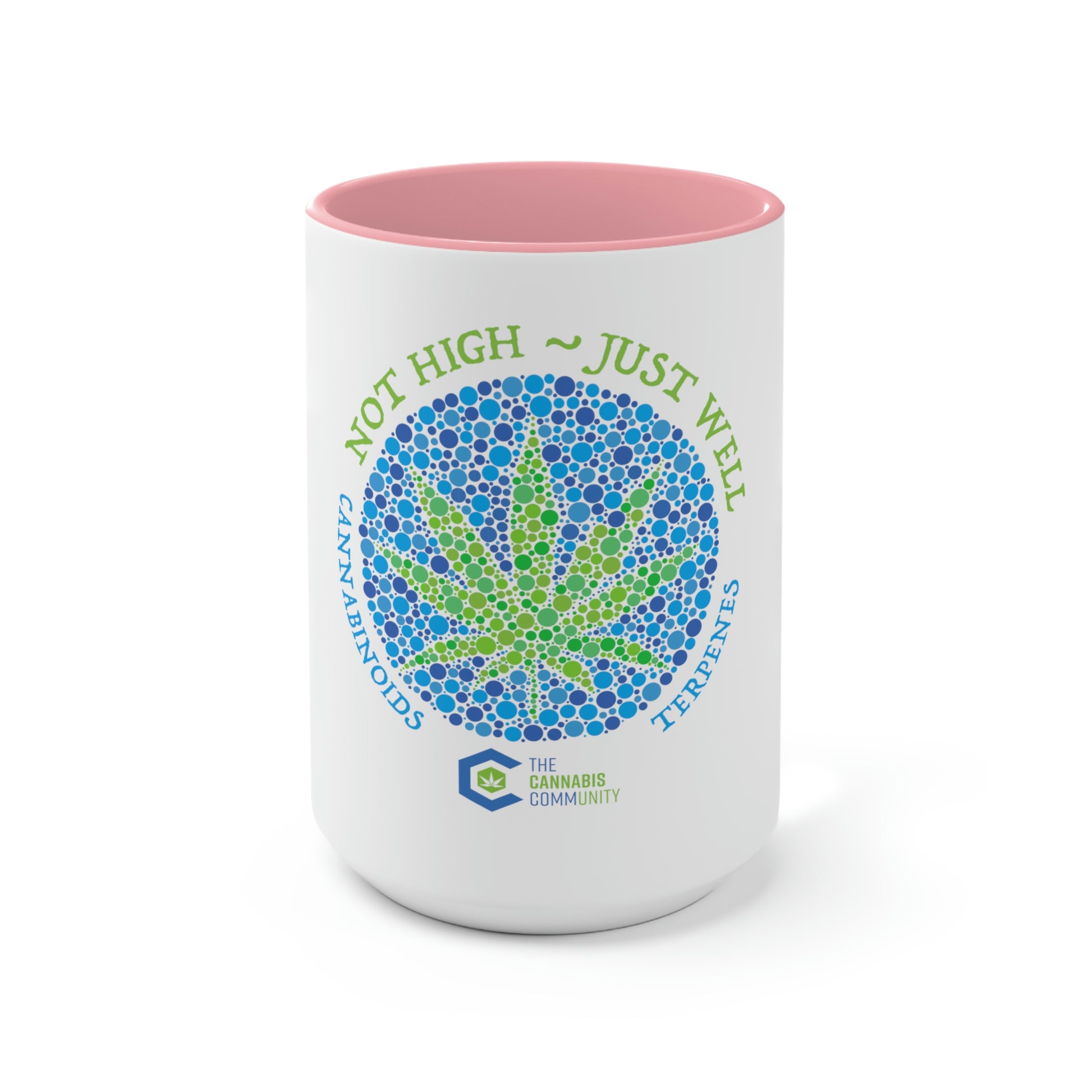 The front side of the pink and white "not high, just well" cannabis coffee mug, featuring a cannabis leaf make up of green and blue dots of various sizes.