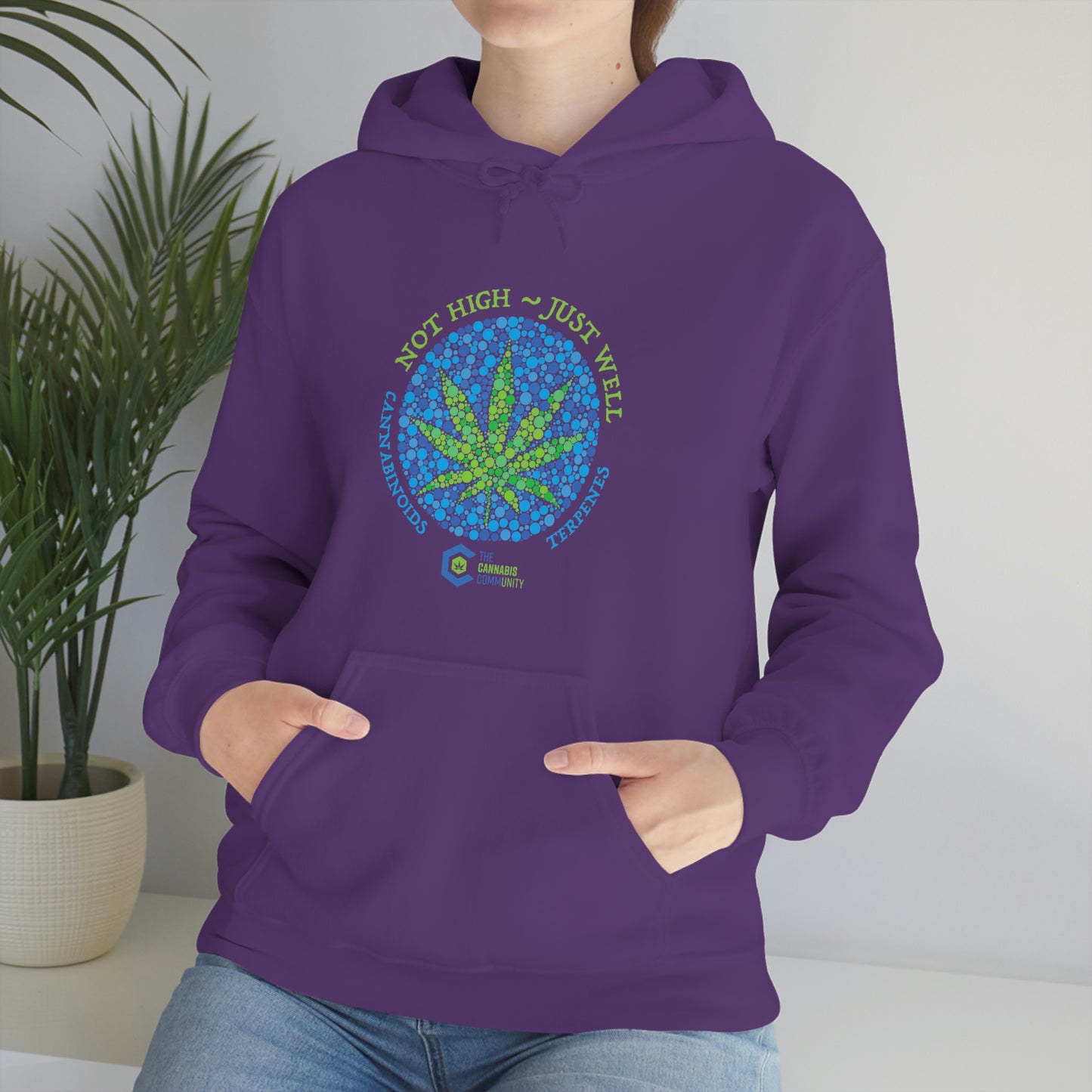 a woman wearing a purple Not High, Just Well Cannabis Hoodie with a marijuana leaf on it.
