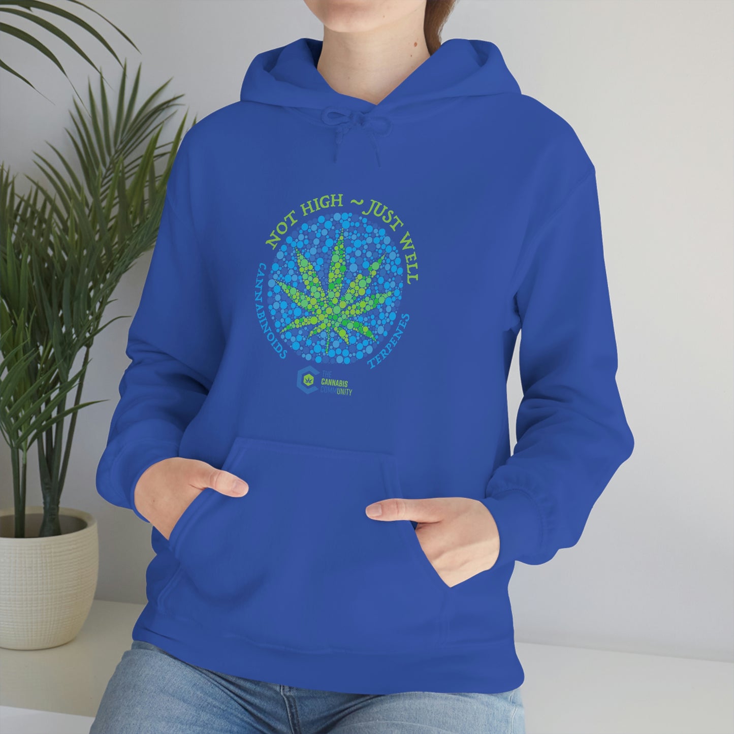 a woman wearing a blue Not High, Just Well Cannabis Hoodie.