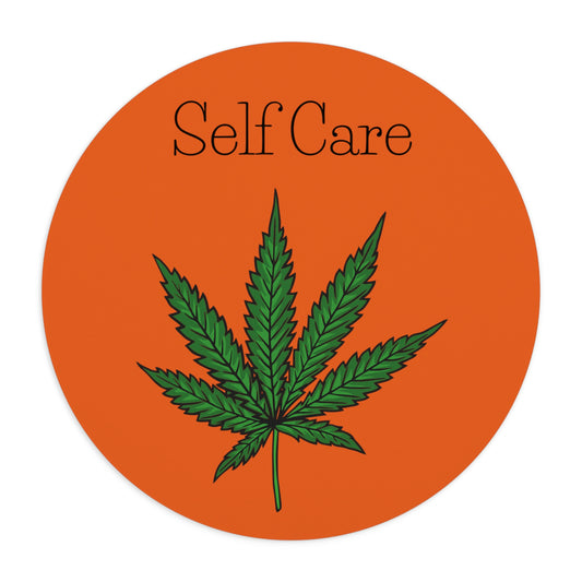 A great picture of the orange Self Care Cannabis Mouse Pad with huge weed leaf underneath the words self care.