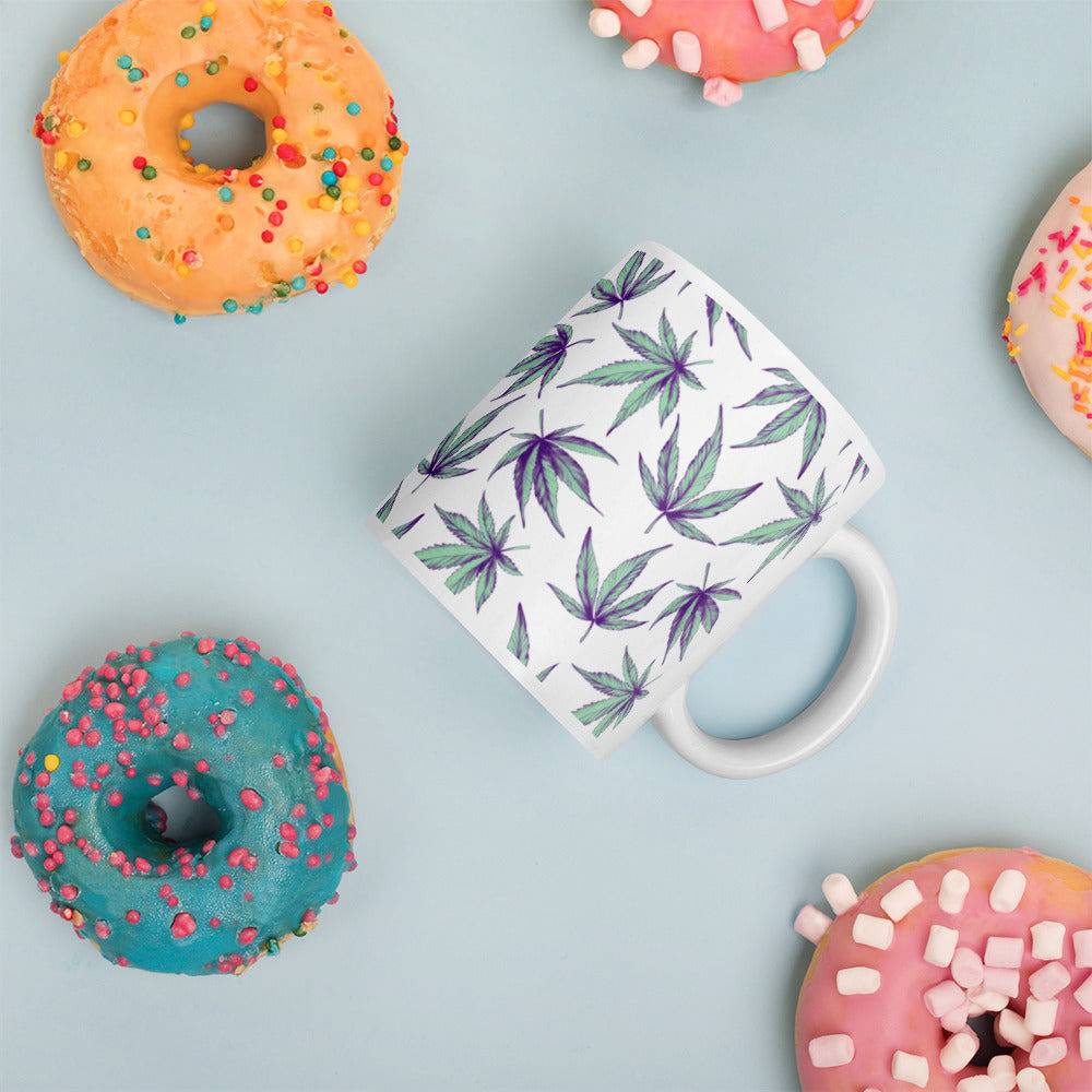 Minty Flower Cannabis Mug and four colored donuts against a light blue background
