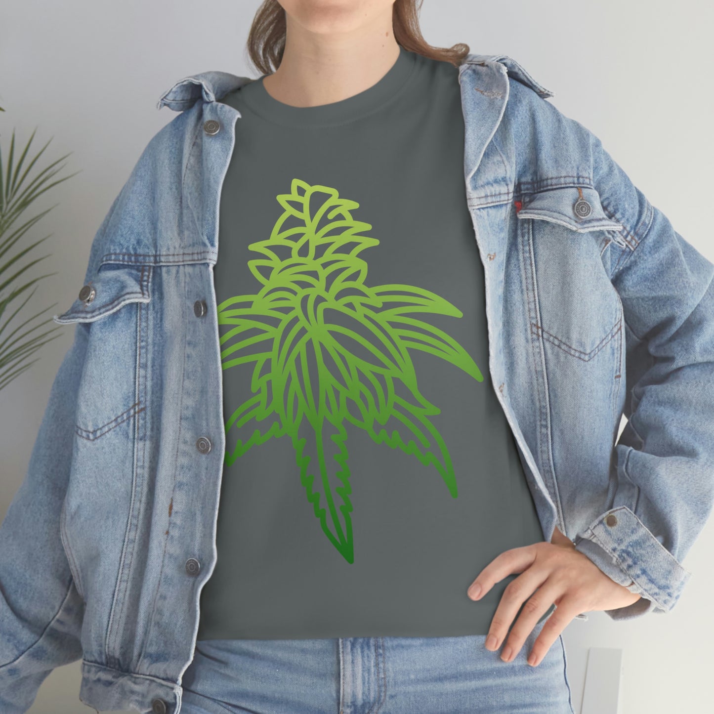 A woman wearing a Sour Diesel Cannabis Tee with a green marijuana leaf on it.