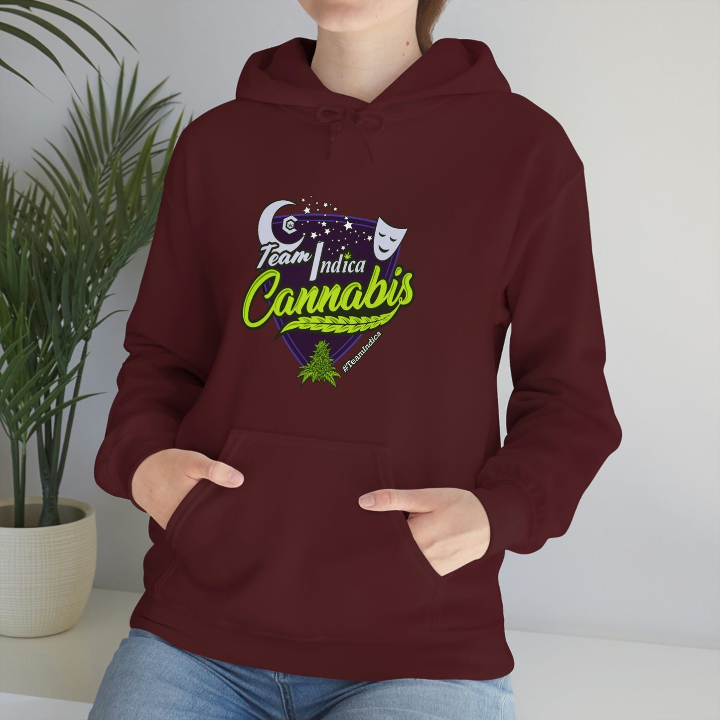 a woman wearing a maroon hoodie with the Team Indica Cannabis Pullover on it.