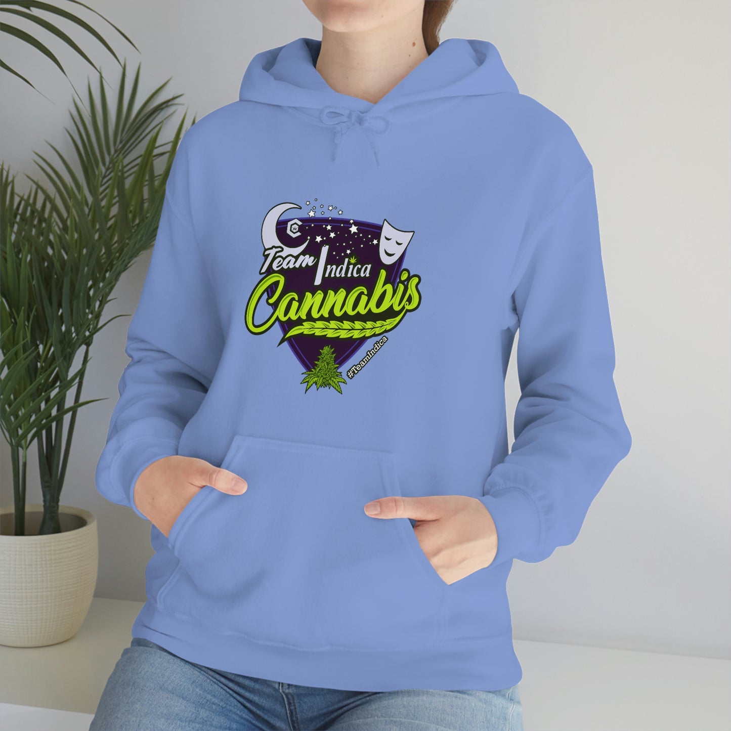 a woman wearing a blue hoodie with the words "Team Indica Cannabis Pullover" on it.