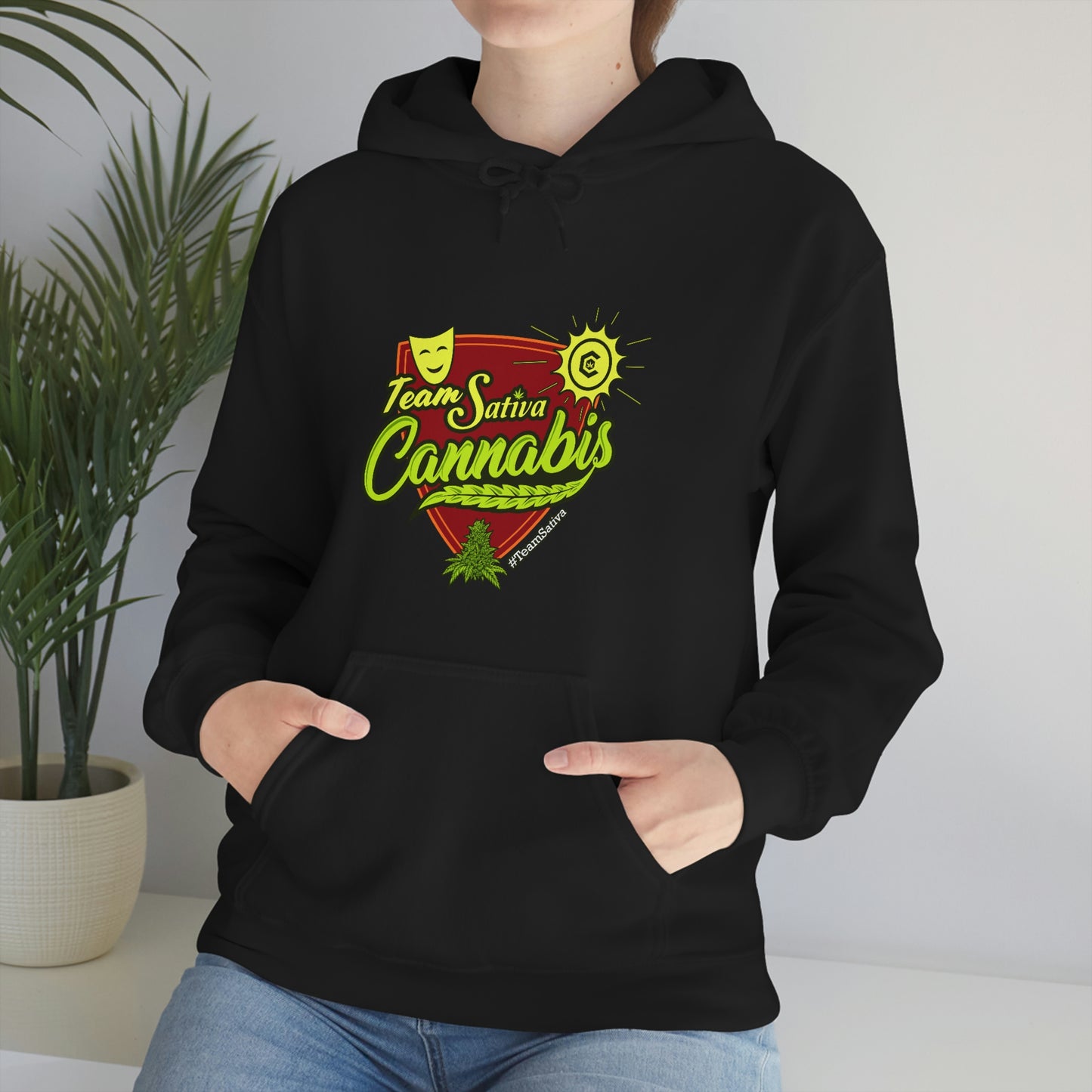a woman wearing a black hoodie with the words "Team Sativa Stoner Sweatshirt" on it.