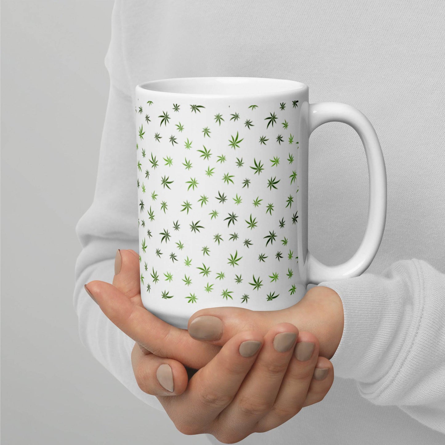 a woman holding a Cannabis Leaf Pattern Mug with green leaves on it.