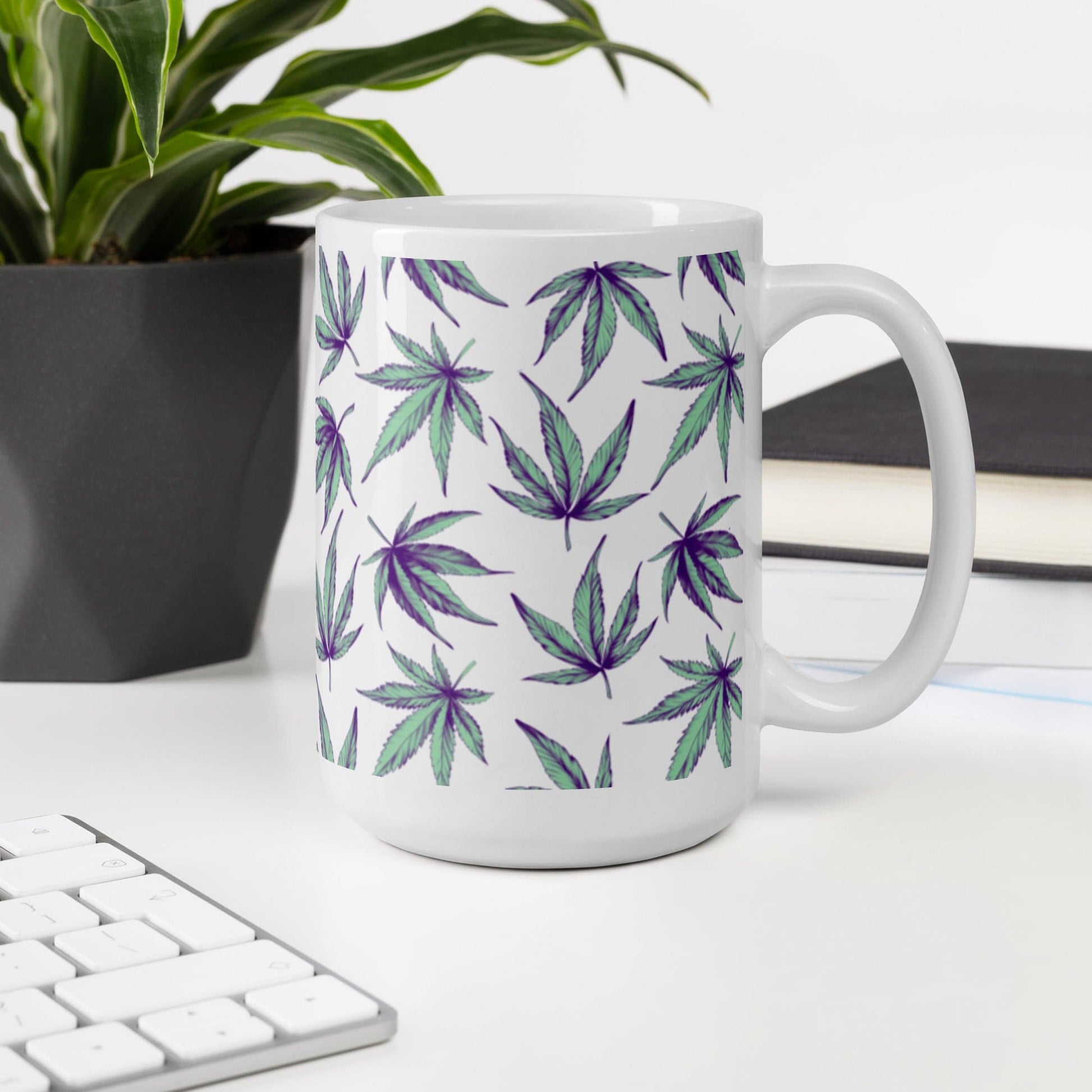 A larger Minty Flower Cannabis Mug that fits up to 15 ounces, on a white desk with a black flower pot and keyboard next to it