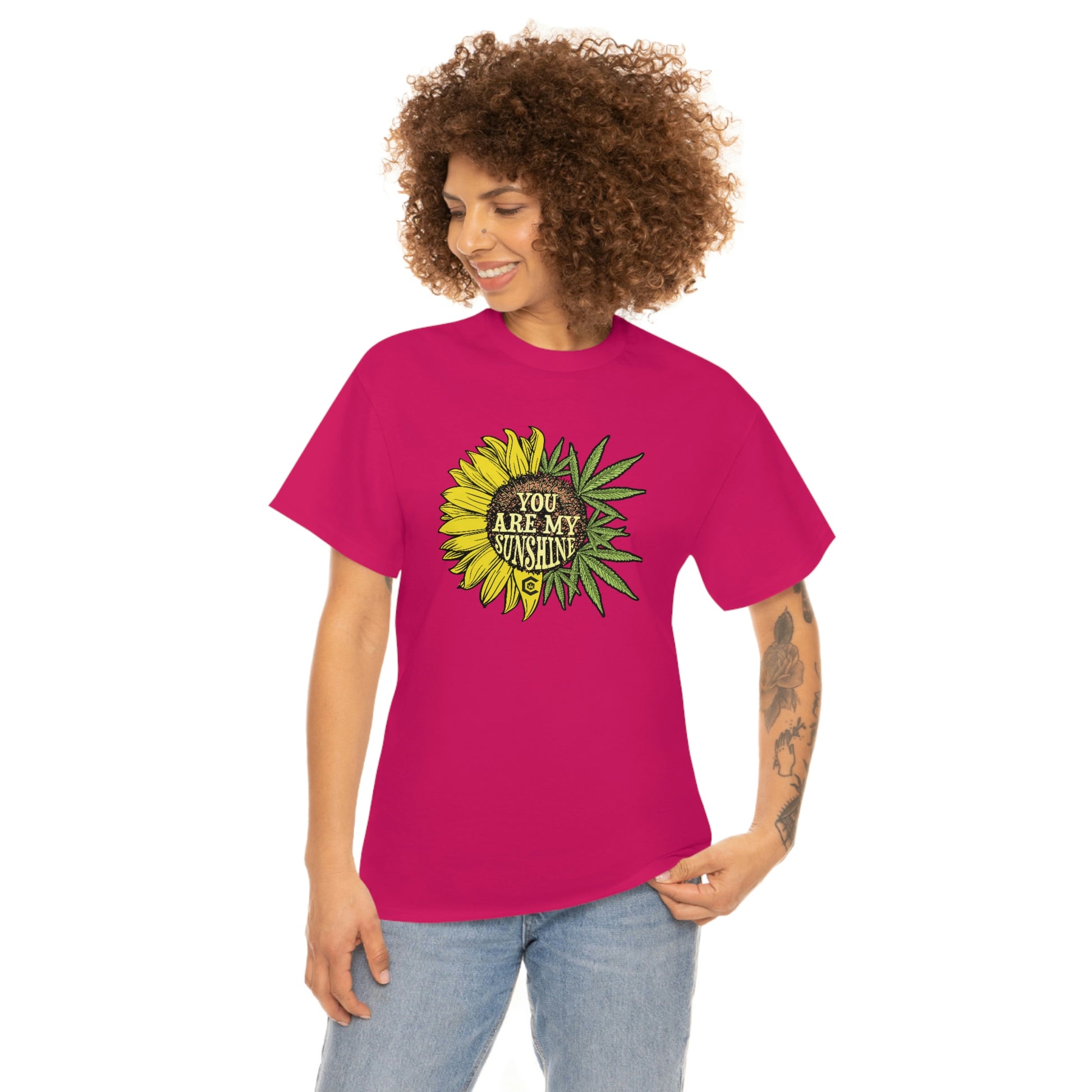 a woman wearing a pink "You Are My Sunshine Weed" t - shirt with a sunflower on it.