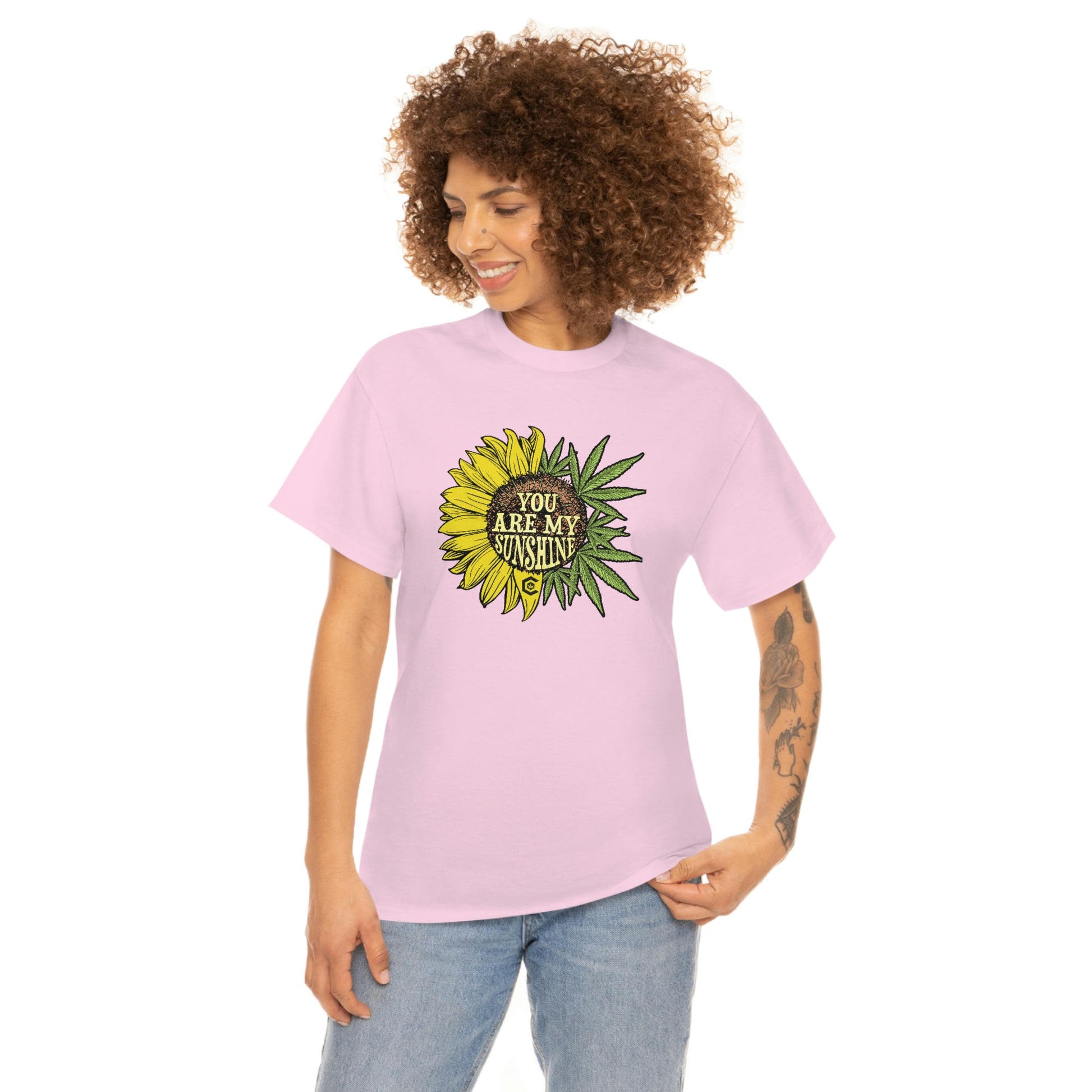a woman wearing a pink "You Are My Sunshine Weed" T-Shirt with a sunflower on it.