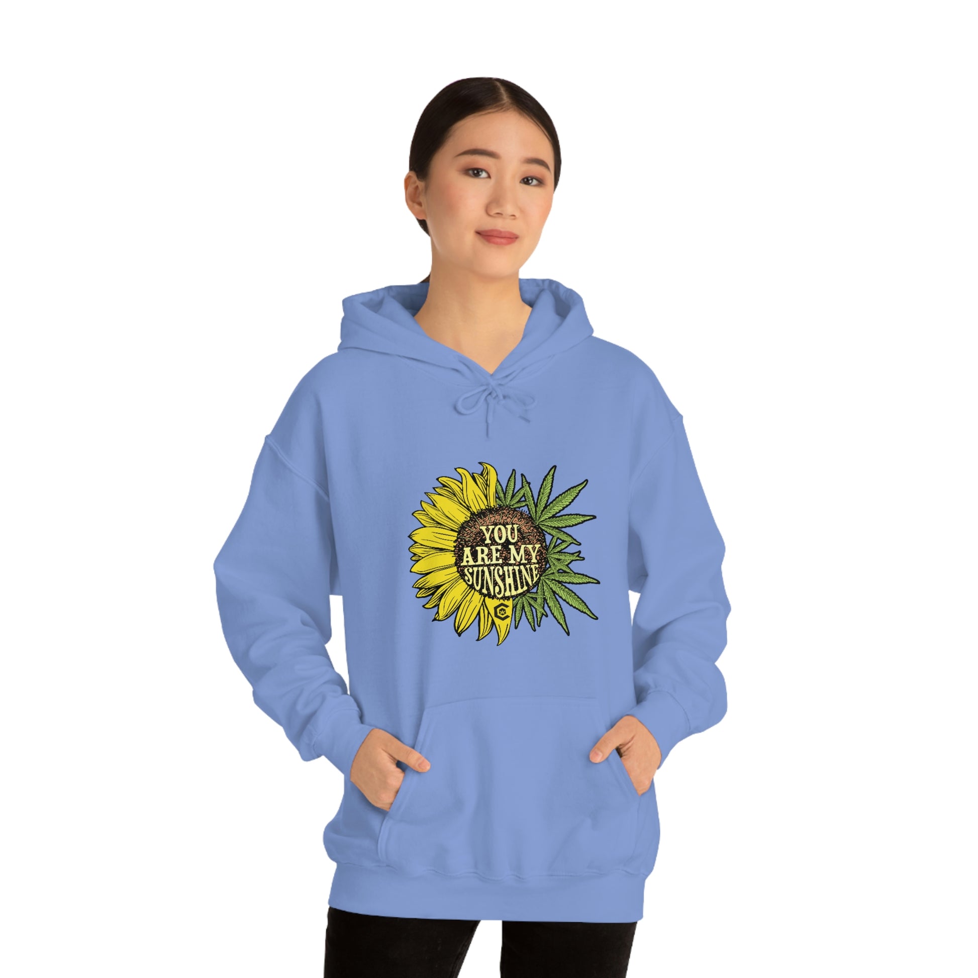 a woman wearing a You Are My Sunshine Cannabis Sweatshirt with a sunflower on it.