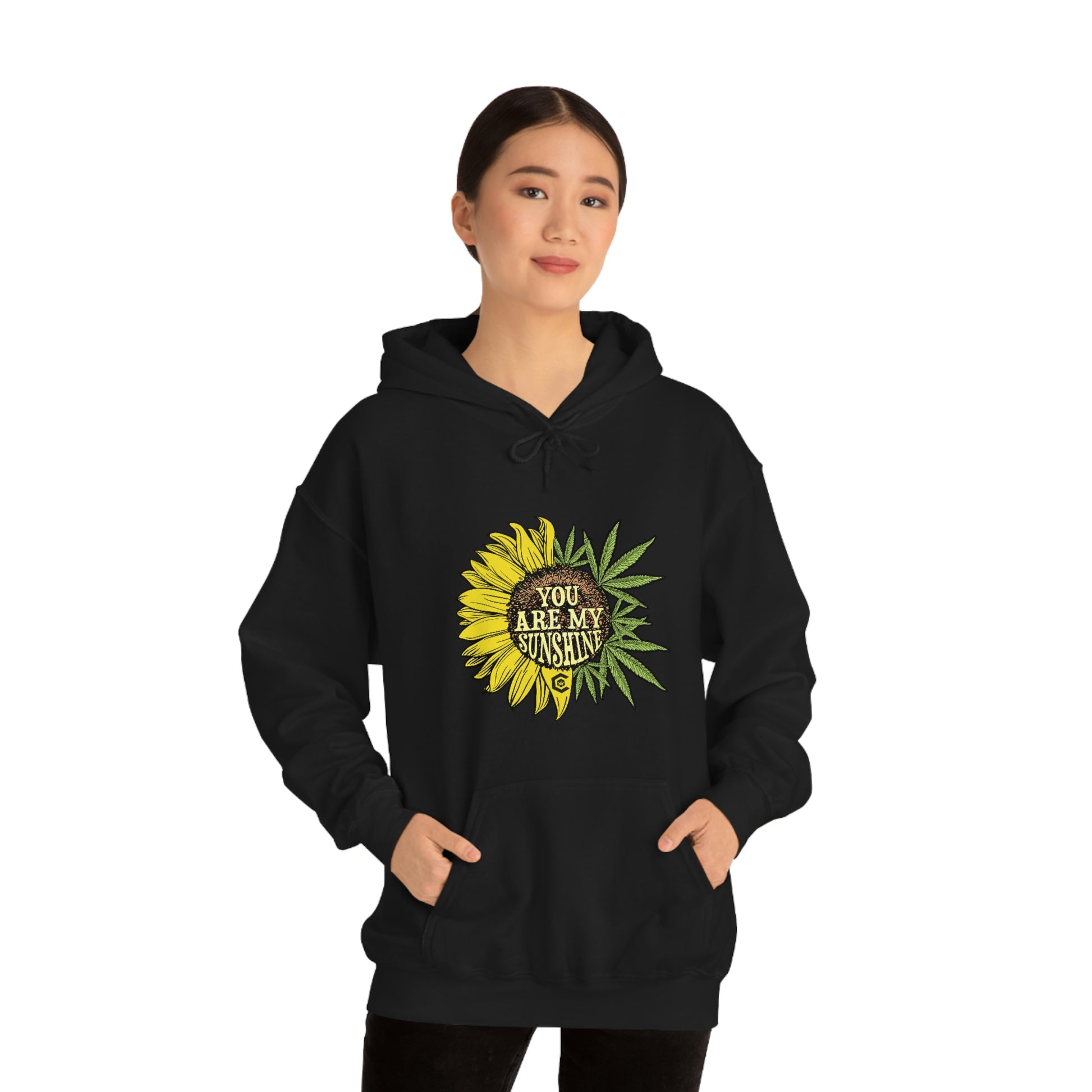a woman wearing a black hoodie with a You Are My Sunshine Cannabis Sweatshirt on it.