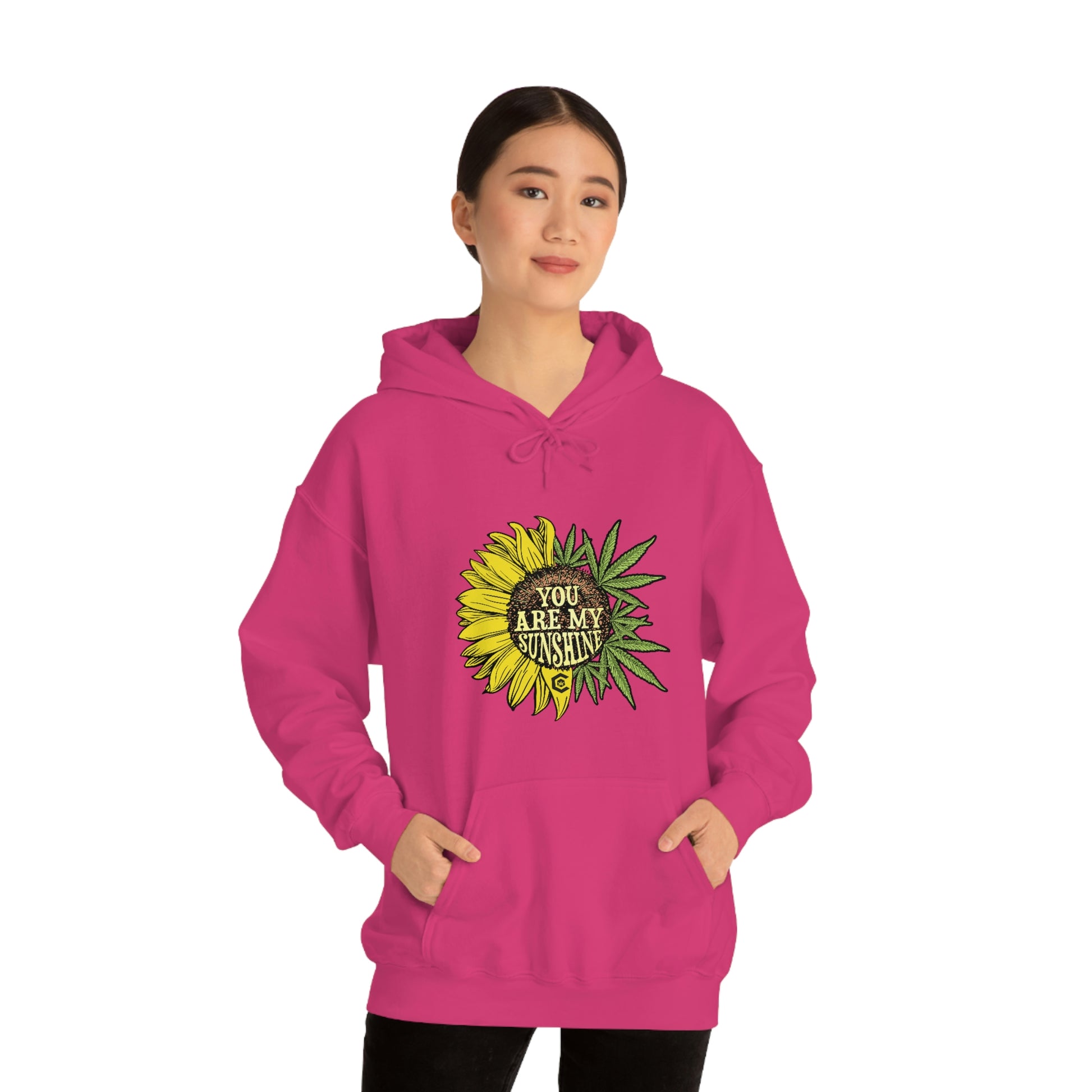 a woman wearing a pink hoodie with the You Are My Sunshine Cannabis Sweatshirt on it.