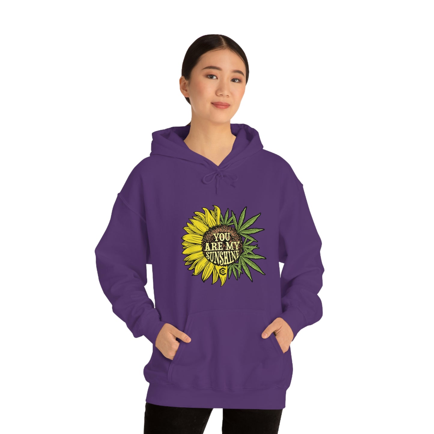 a woman wearing a purple hoodie with a You Are My Sunshine Cannabis Sweatshirt on it.