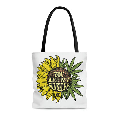 Half sunflower half cannabis leaves with the sunflower being colored yellow and the weed leaves are colored green on the You Are My Sunshine Marijuana Tote Bag